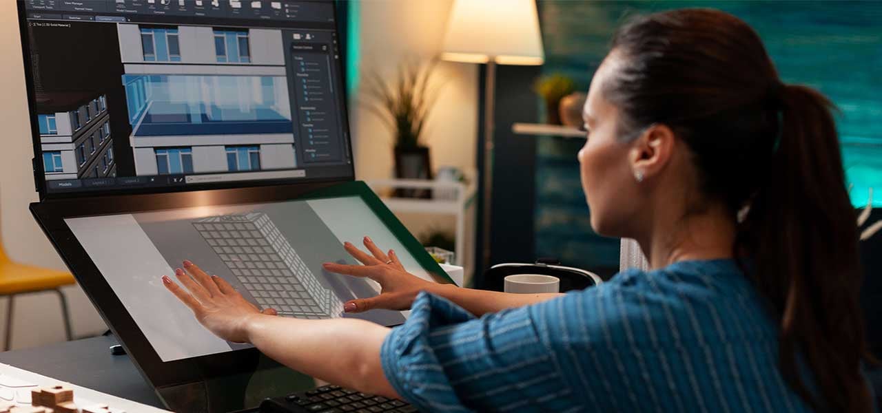 Frau arbeitet an einem Gebäudeplan am Computer