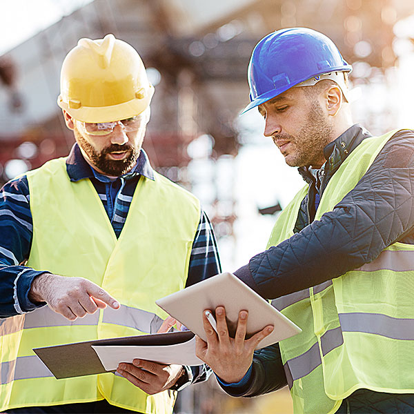 Zwei Bauarbeiter besprechen Bauprojekt Zwei Bauarbeiter besprechen Bauprojekt